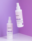 Lifestyle photo of 2 bottles of HOLD Volumizing Hair Spray-InStyler