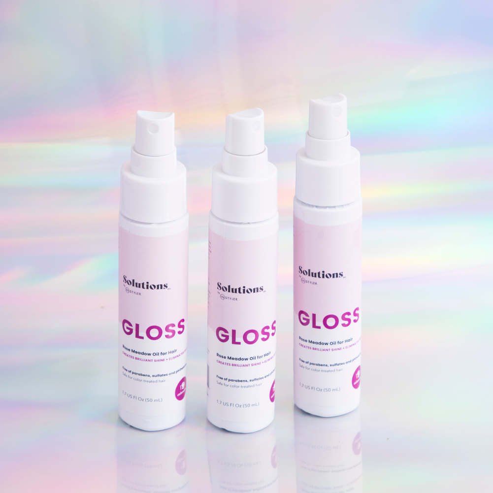 Lifestyle photo of 3 bottles of GLOSS Rose Meadow Hair Oil-InStyler