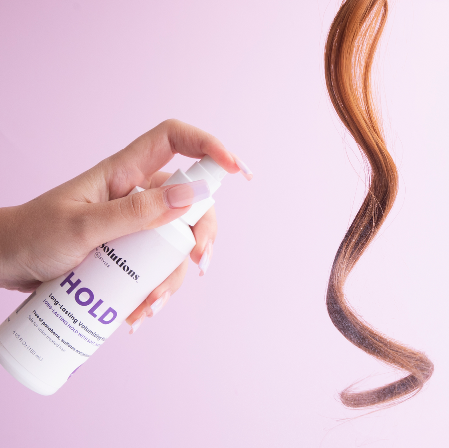 Photo of long brown hair being sprayed with HOLD Volumizing Hair Spray-InStyler