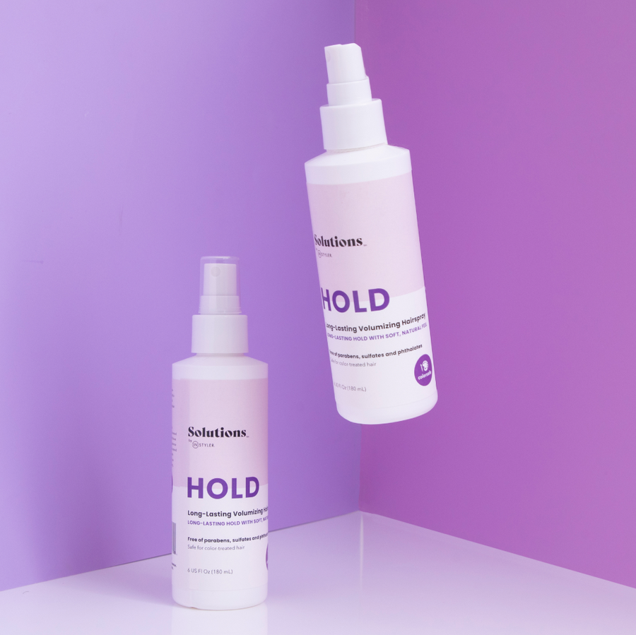 Lifestyle photo of 2 bottles of HOLD Volumizing Hair Spray-InStyler