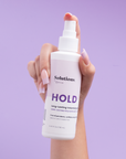 Model holding bottle of HOLD-Volumizing Hair Spray-InStyler