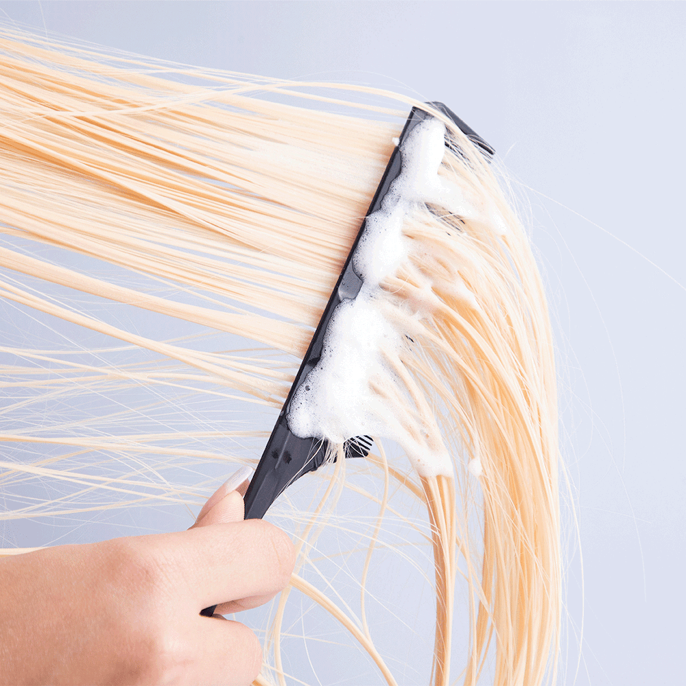 Comb being pulled through blonde hair using PROTECT Foam Heat Protectant-InStyler