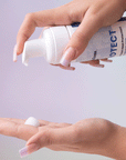 Photo of model squirting bottle of PROTECT Foam Heat Protectant into hand-InStyler